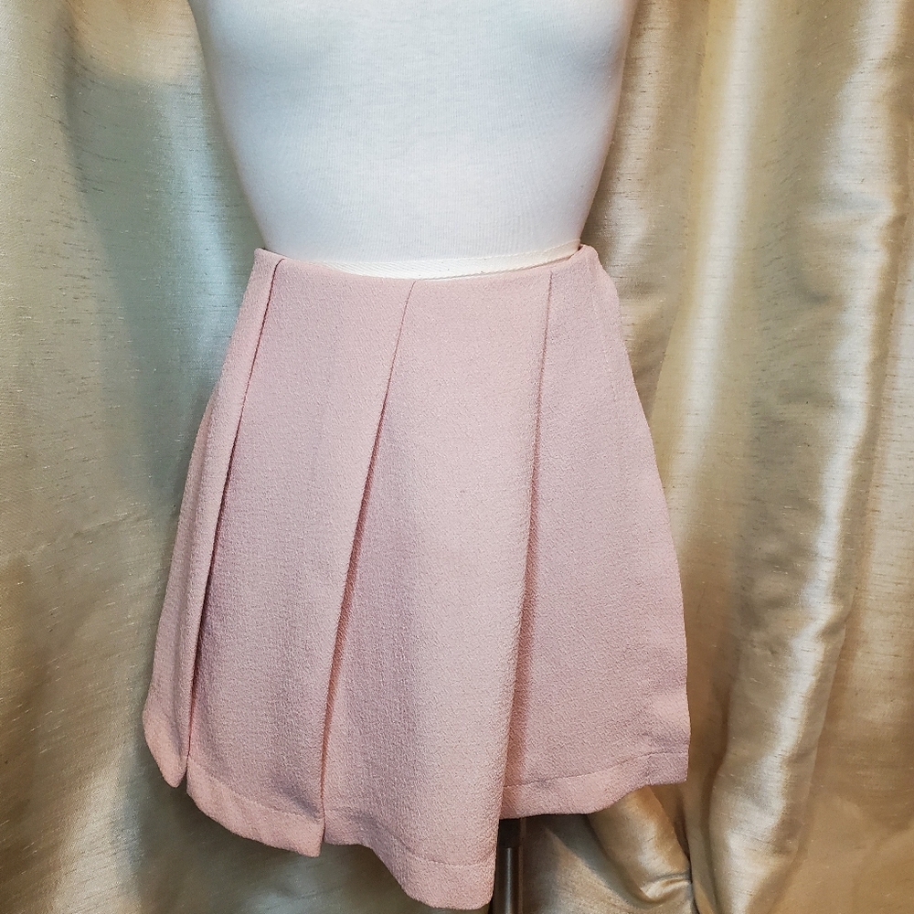 Pink shorts with pleated skirt overlay.